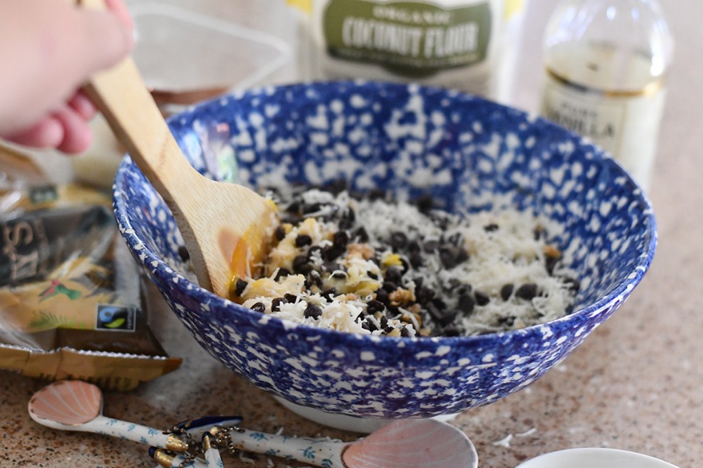 blue bowl with ingredients for keto chocolate chip coconut cookie