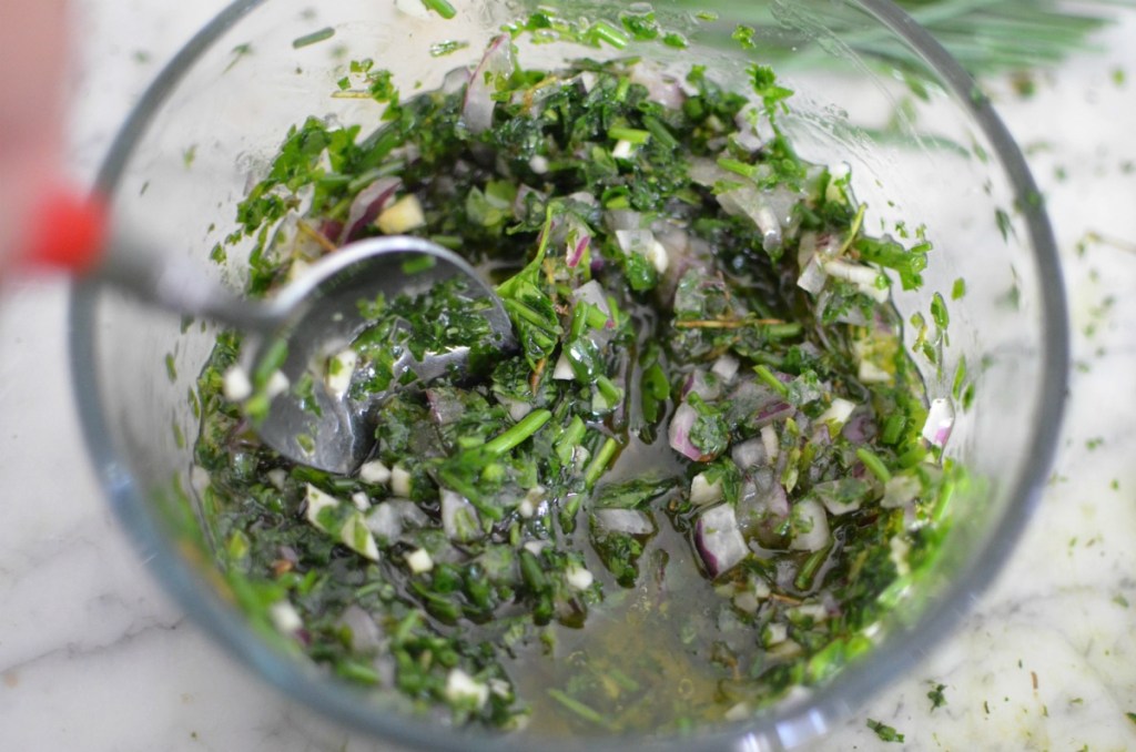 mixing chimichurri sauce in a bowl