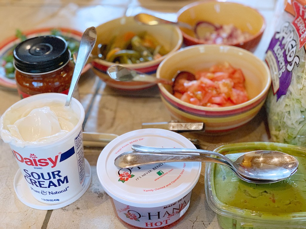 sour cream, guacamole, and other toppings for nacho bar