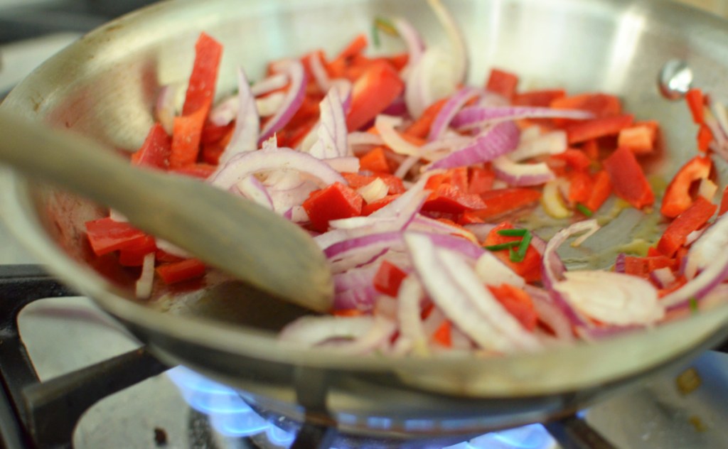 onions and peppers in a saute pan
