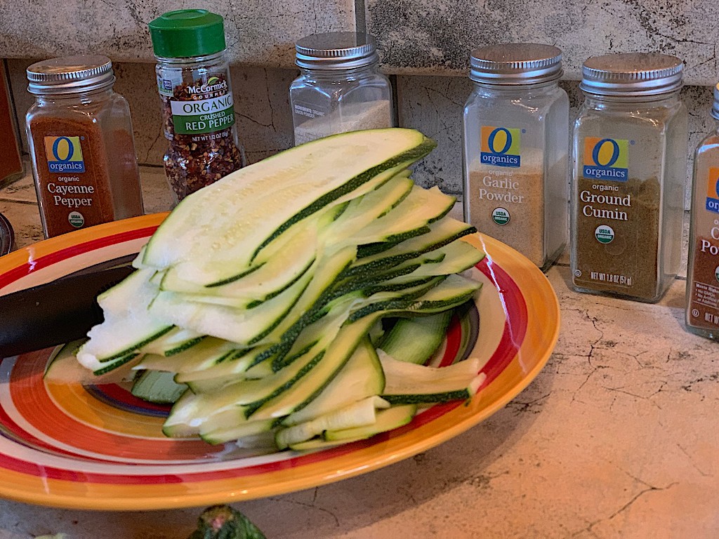 sliced zucchini on plate with spices in the background 