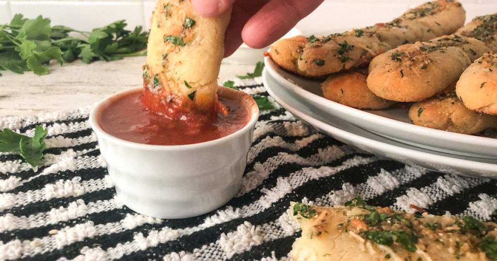 dipping breadstick in marinara sauce