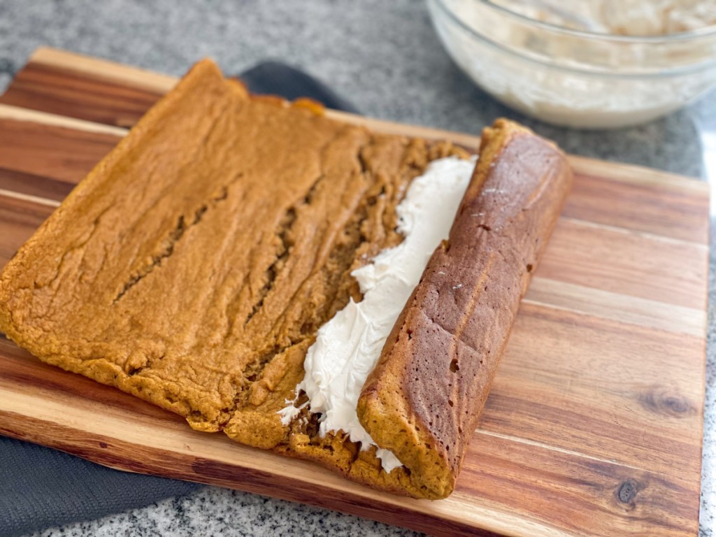 filling Keto Pumpkin Roll with cream cheese filling