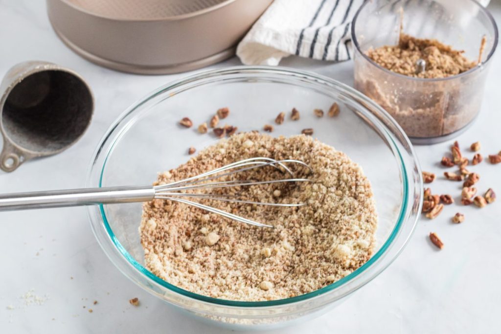 Chopped pecans in a mixing bowl creating crust