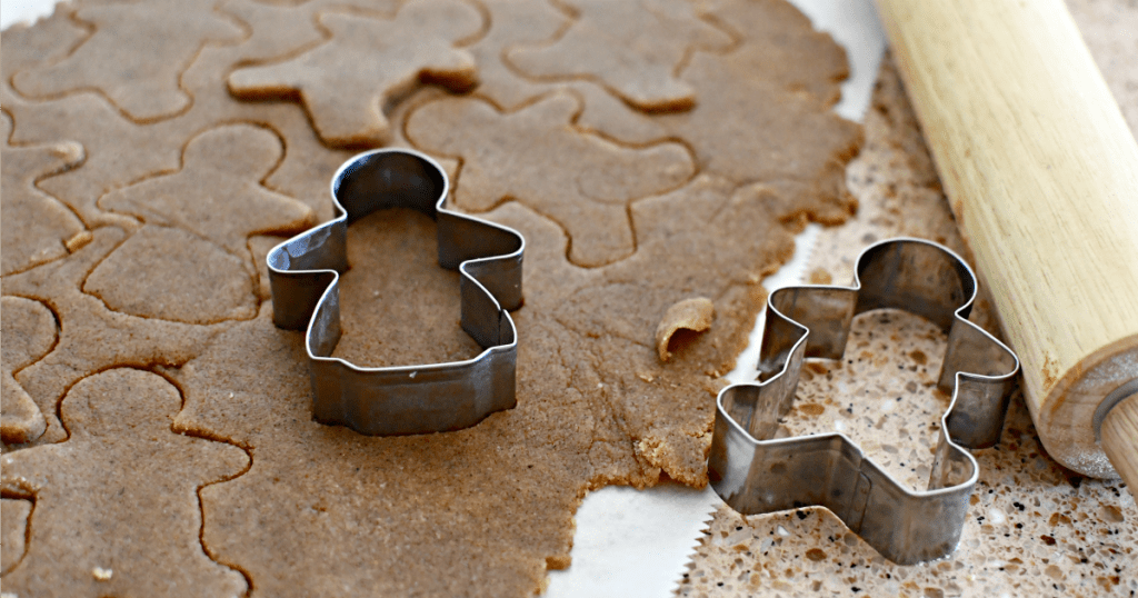 cutting out keto gingerbread cookies with cookie cutter