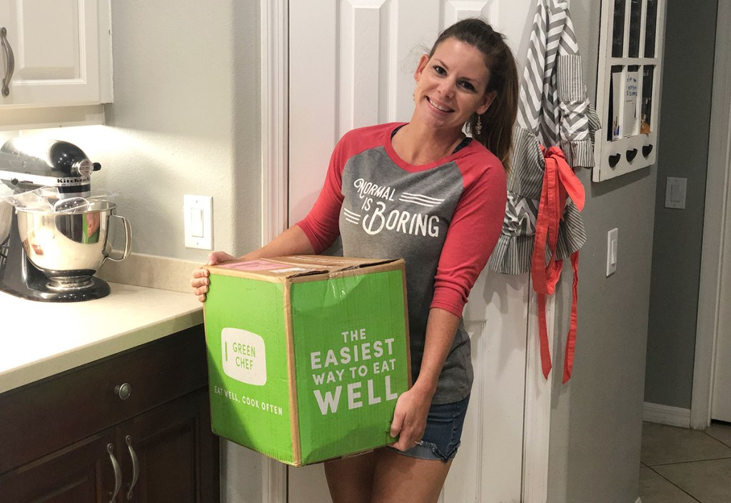 woman carrying Green Chef meal box into the kitchen