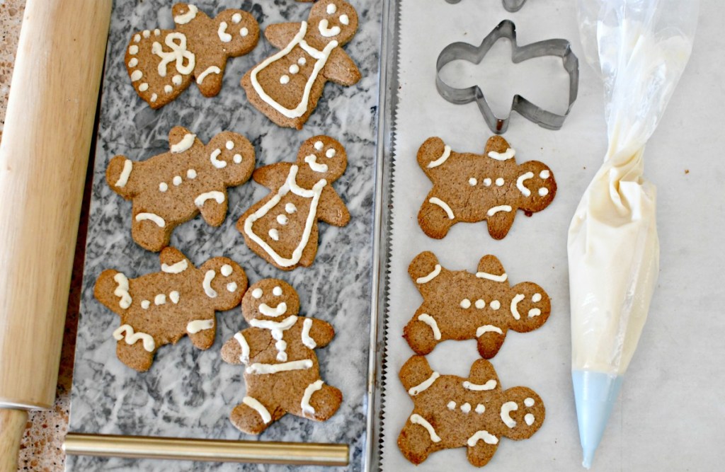 piping frosting onto keto gingerbread cookies 