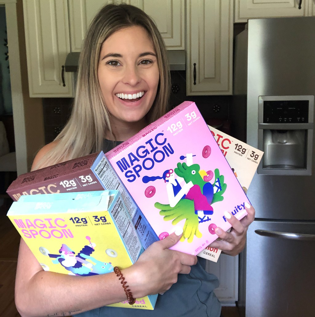 woman holding magic spoon cereal boxes