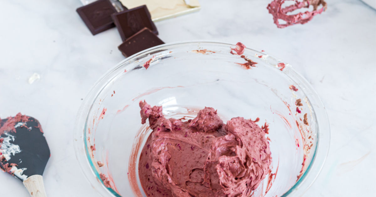 a clear mixing bowl with the red velvet mixture insude