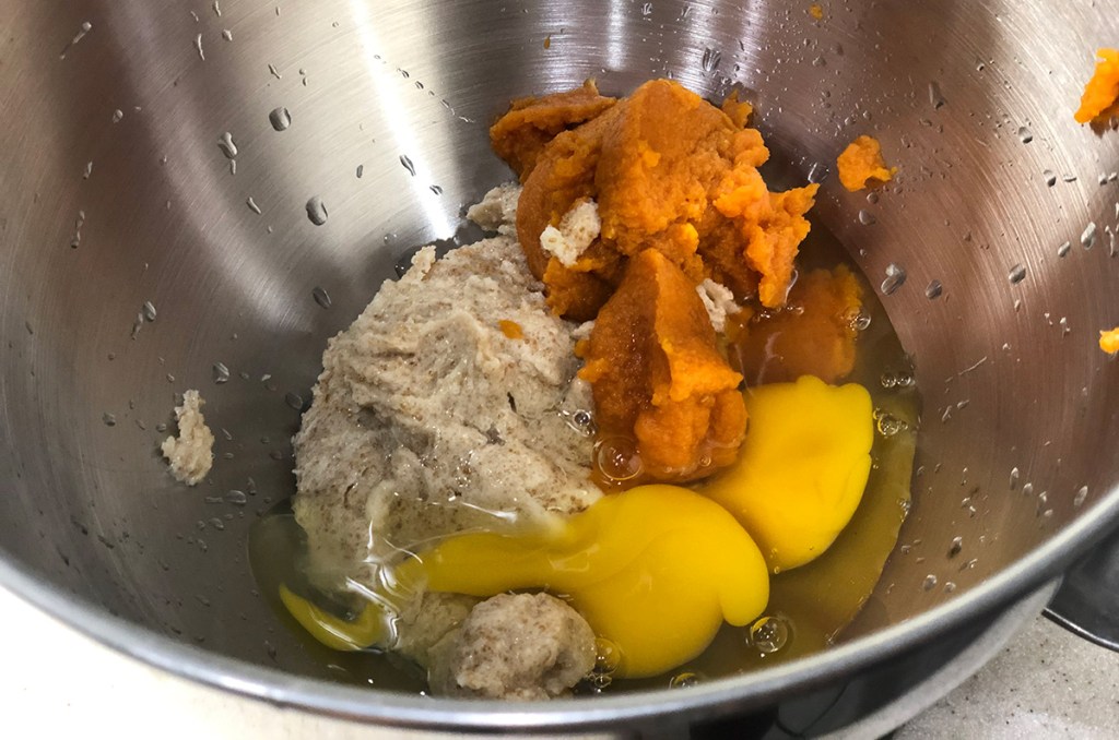 mixing bowl with eggs, pumpkin puree, and butter