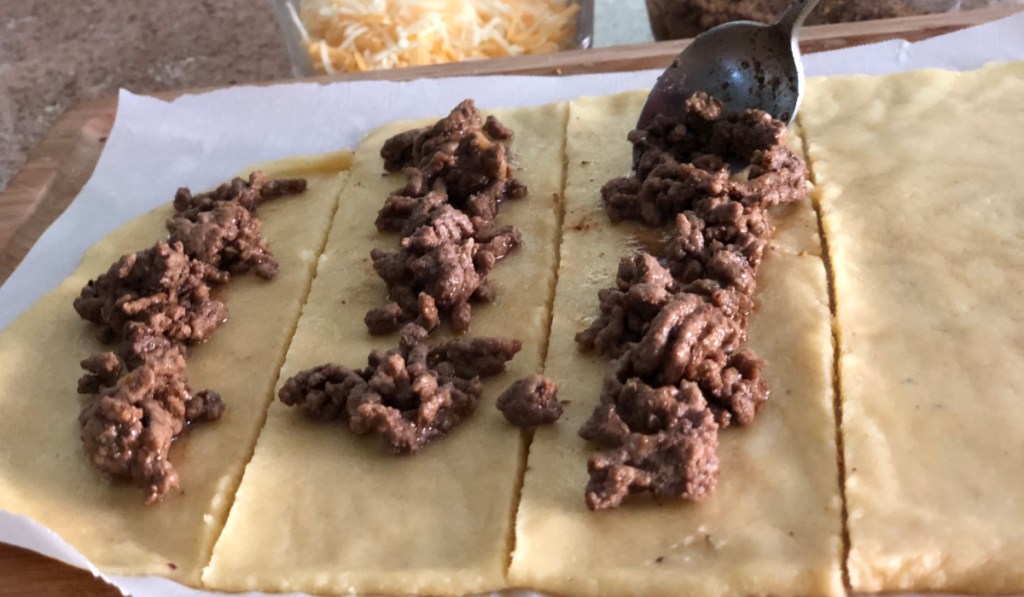 putting taco meat in bread stick