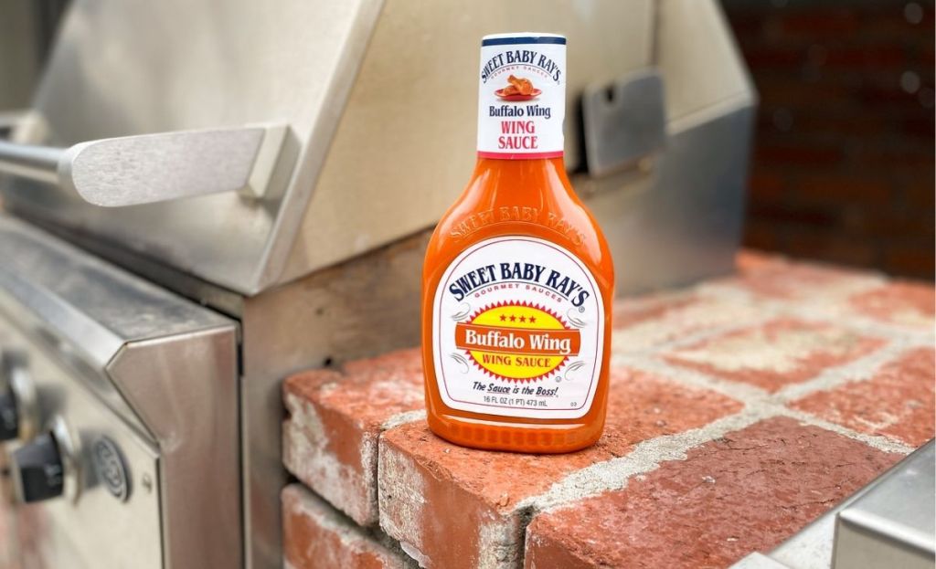 Buffalo wing sauce next to a grill outside