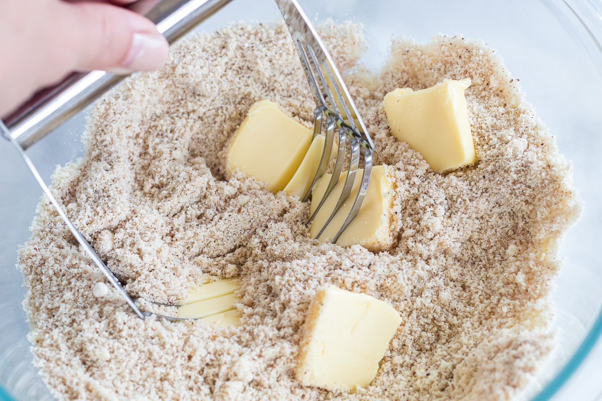 using a pastry blender to mix butter into pie crust