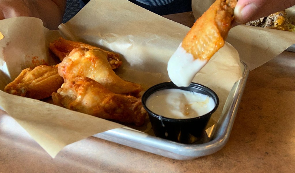 Dipping Buffalo Wild Wings original wings into bleu cheese