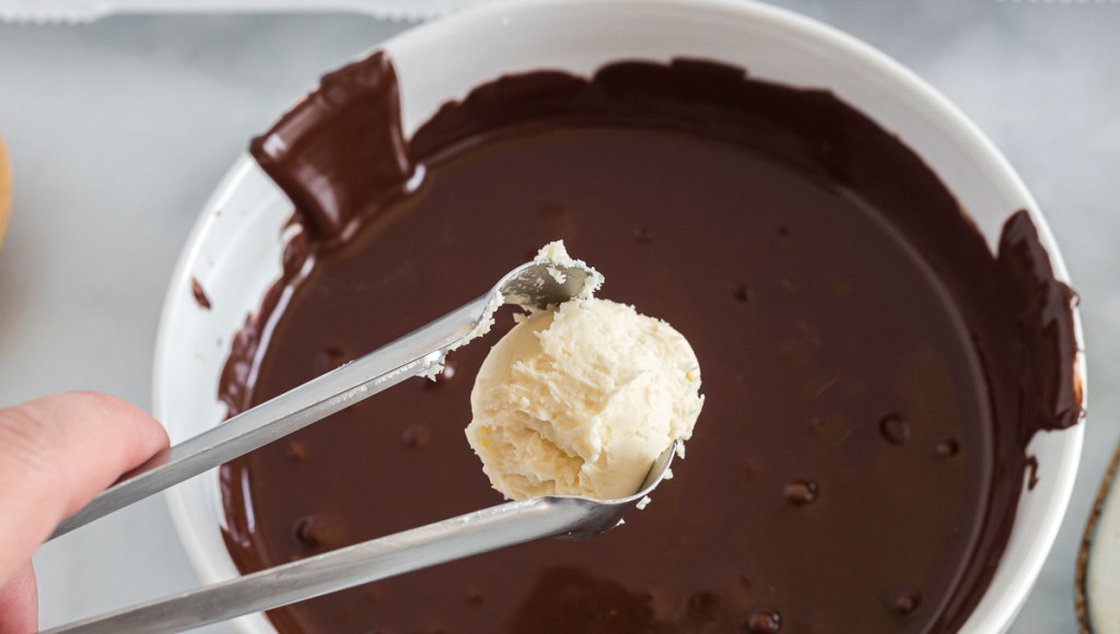 dipping fat bomb into chocolate