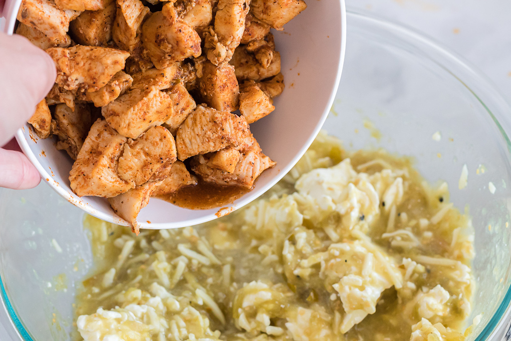 putting chicken in with salsa verde mix