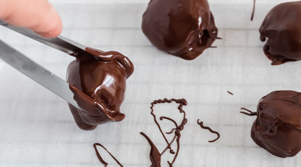 placing chocolate covered fat bomb on tray