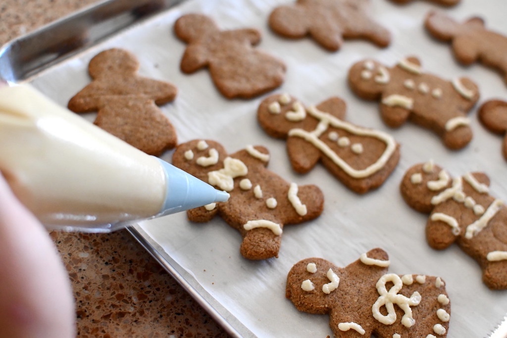 putting frosting on Gingerbread cookies 