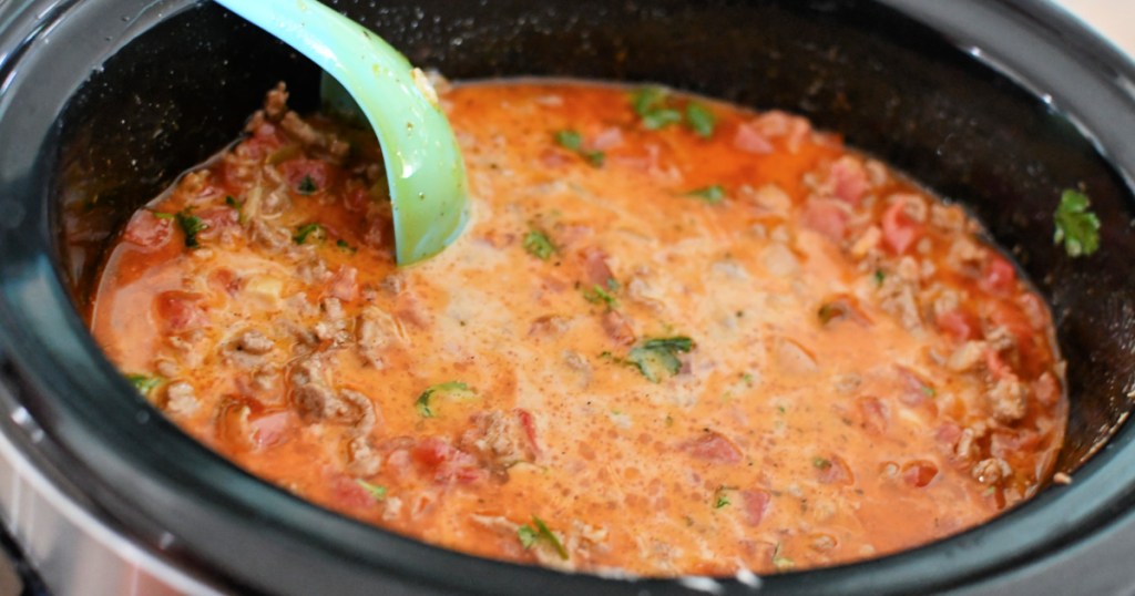 stirring a slow cooker with keto taco soup