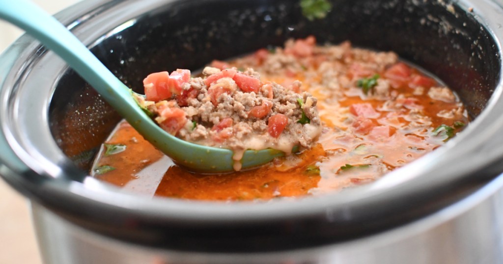 stirring keto taco soup in slow cooker