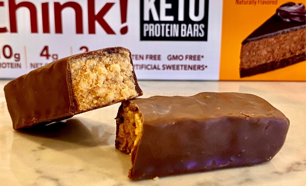 A chocolate protein bar split in half on a counter