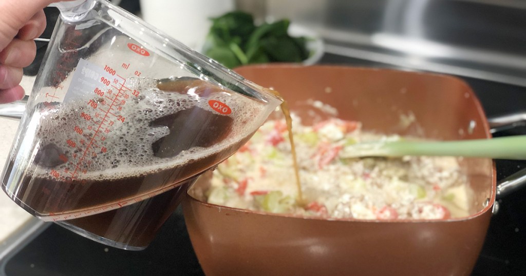 Pouring beef broth into soup pan