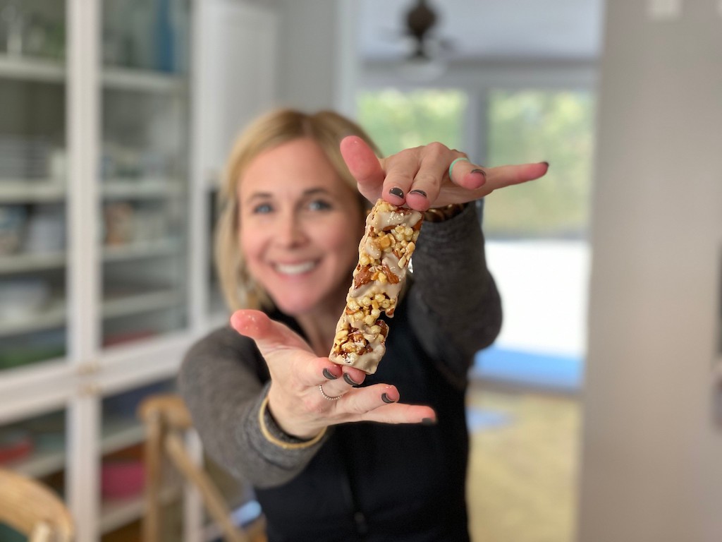 woman holding Quest snack bar 