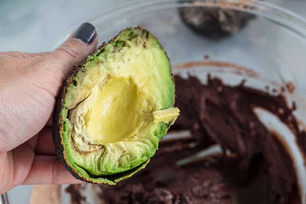 holding avocado over brownie batter bowl 