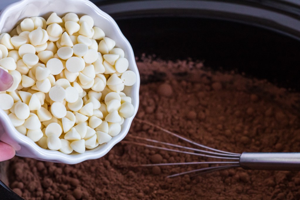 white chocolate chips going into the crockpot