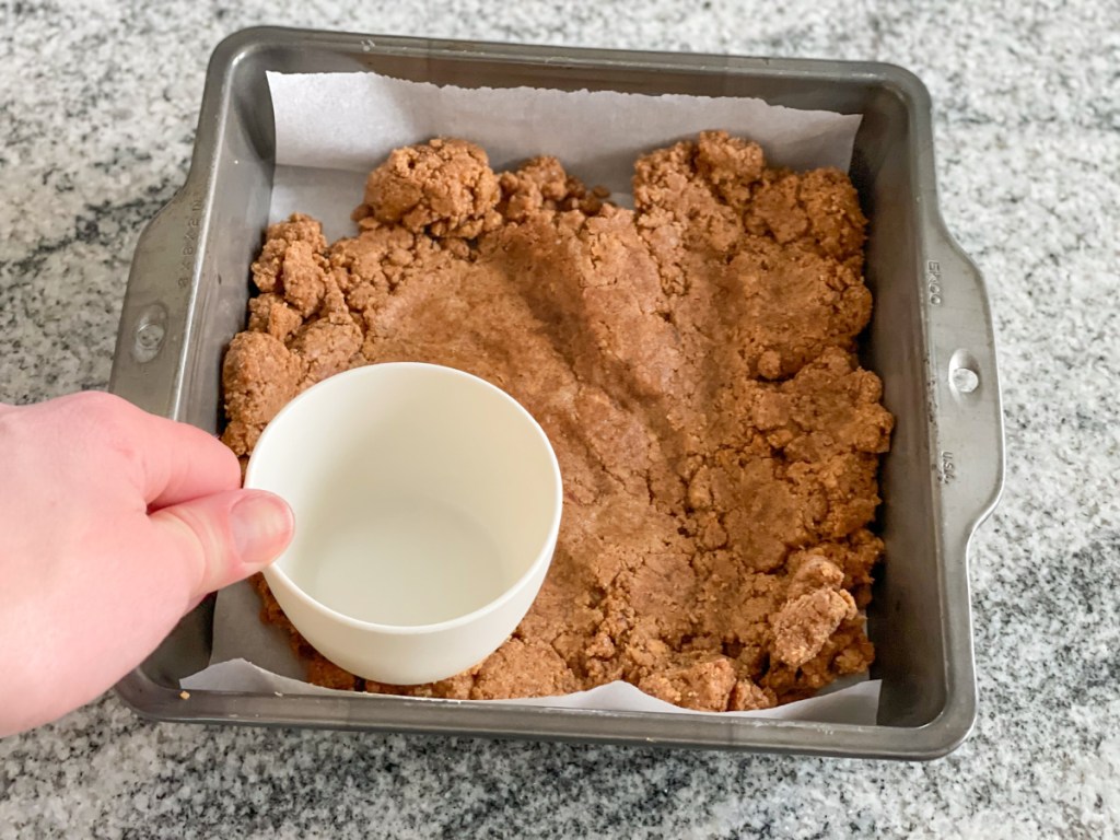 pressing cookie dough protein bar dough into a pan