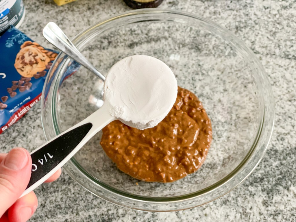 adding keto confectioner sweetener to a bowl with almond butter