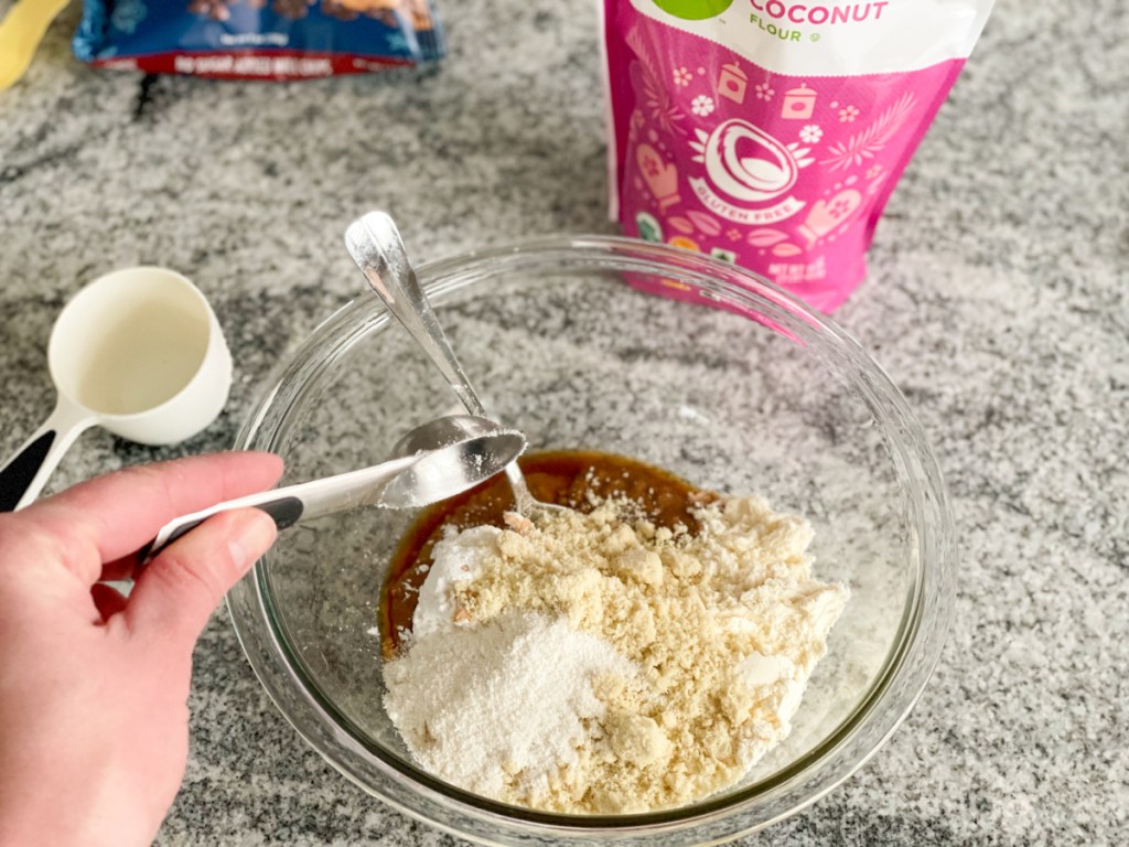 adding coconut flour to a mixing bowl