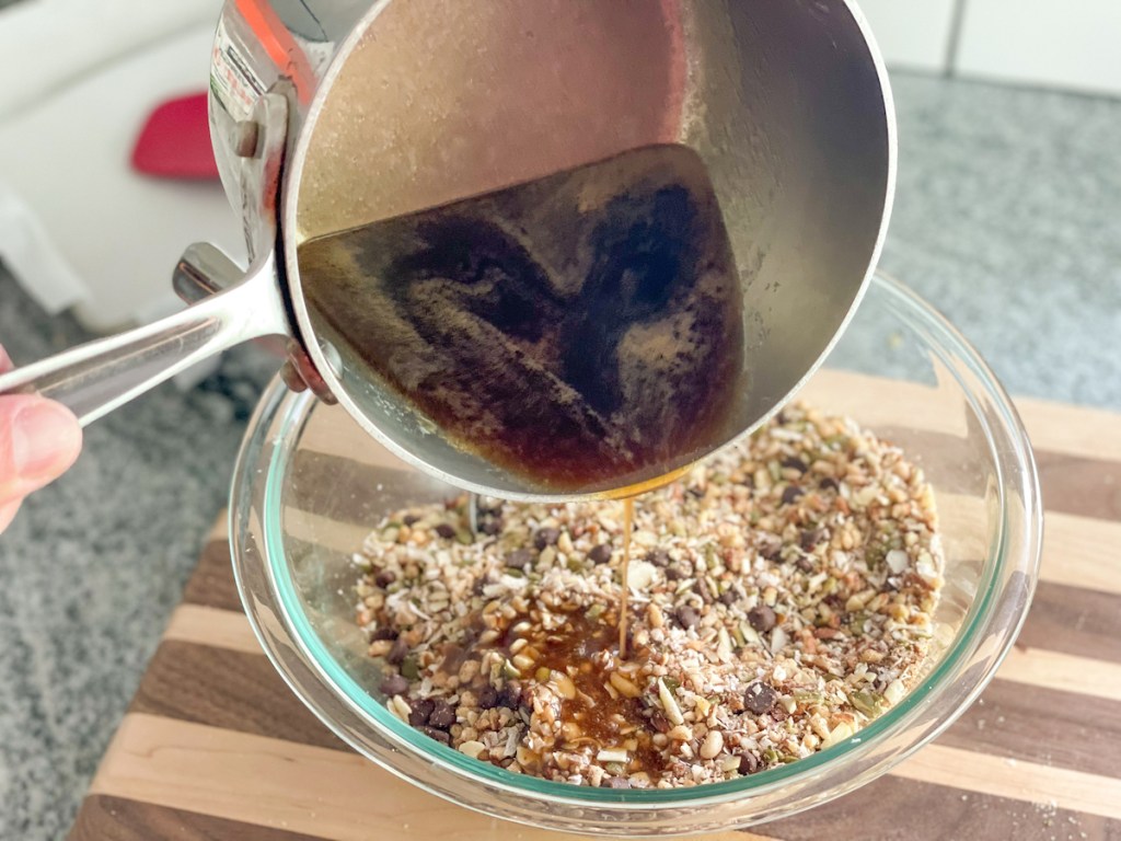 pouring keto caramel sauce over nut mixture