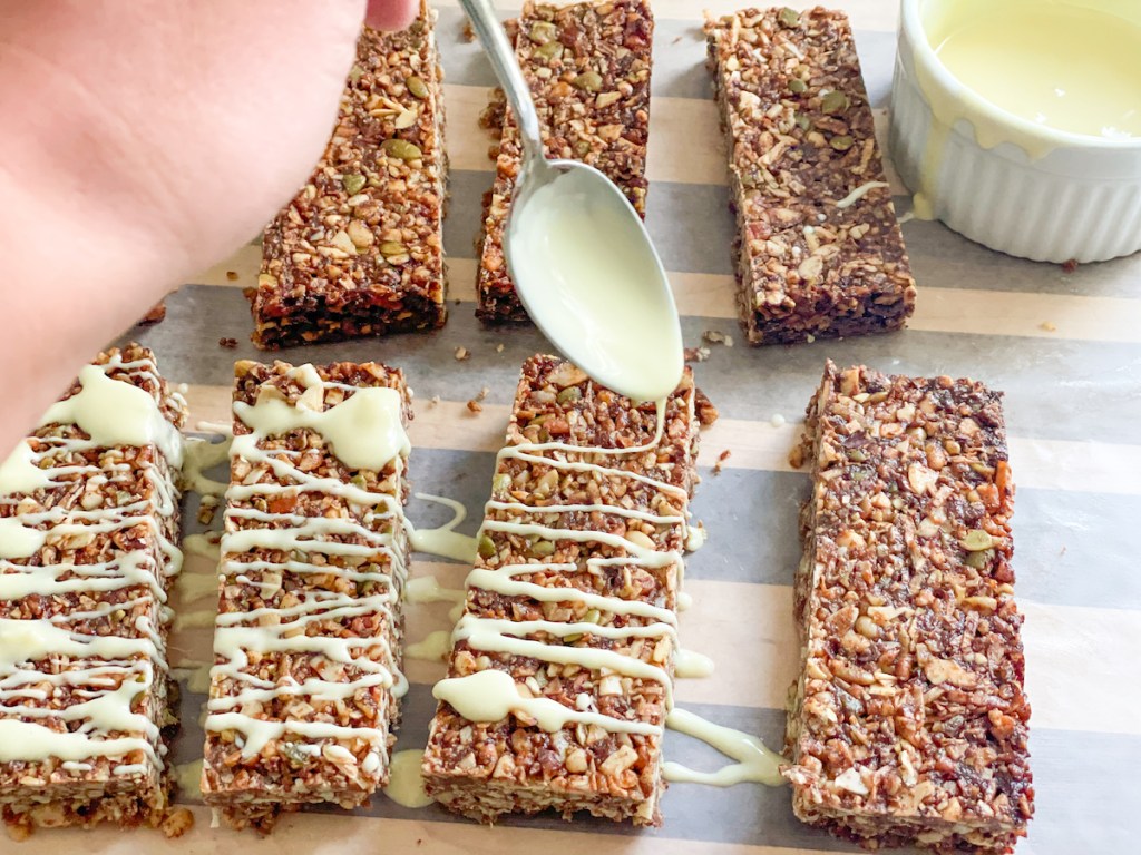 drizzling white chocolate on keto granola bars 