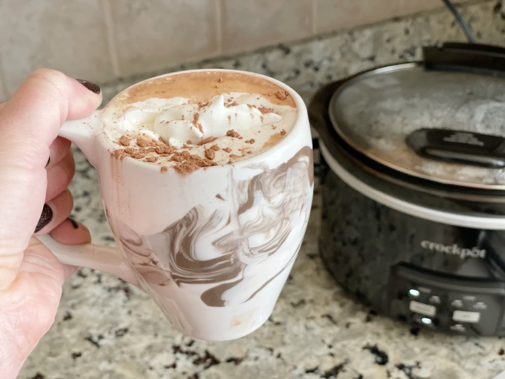 holding a mug of keto hot chocolate