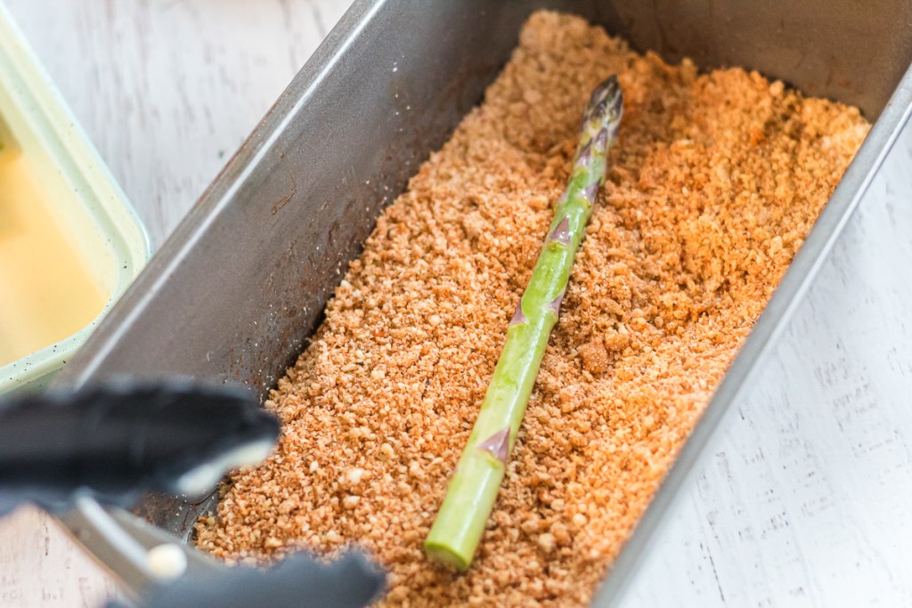 dipping asparagus into crumbs