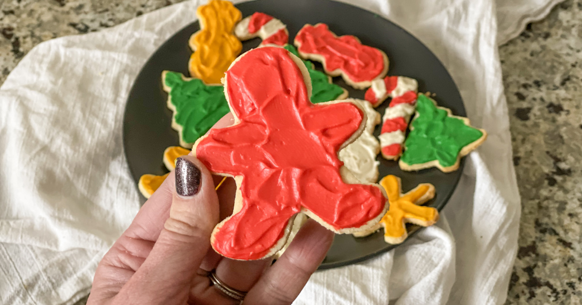 holding a frosted soft keto sugar cookies