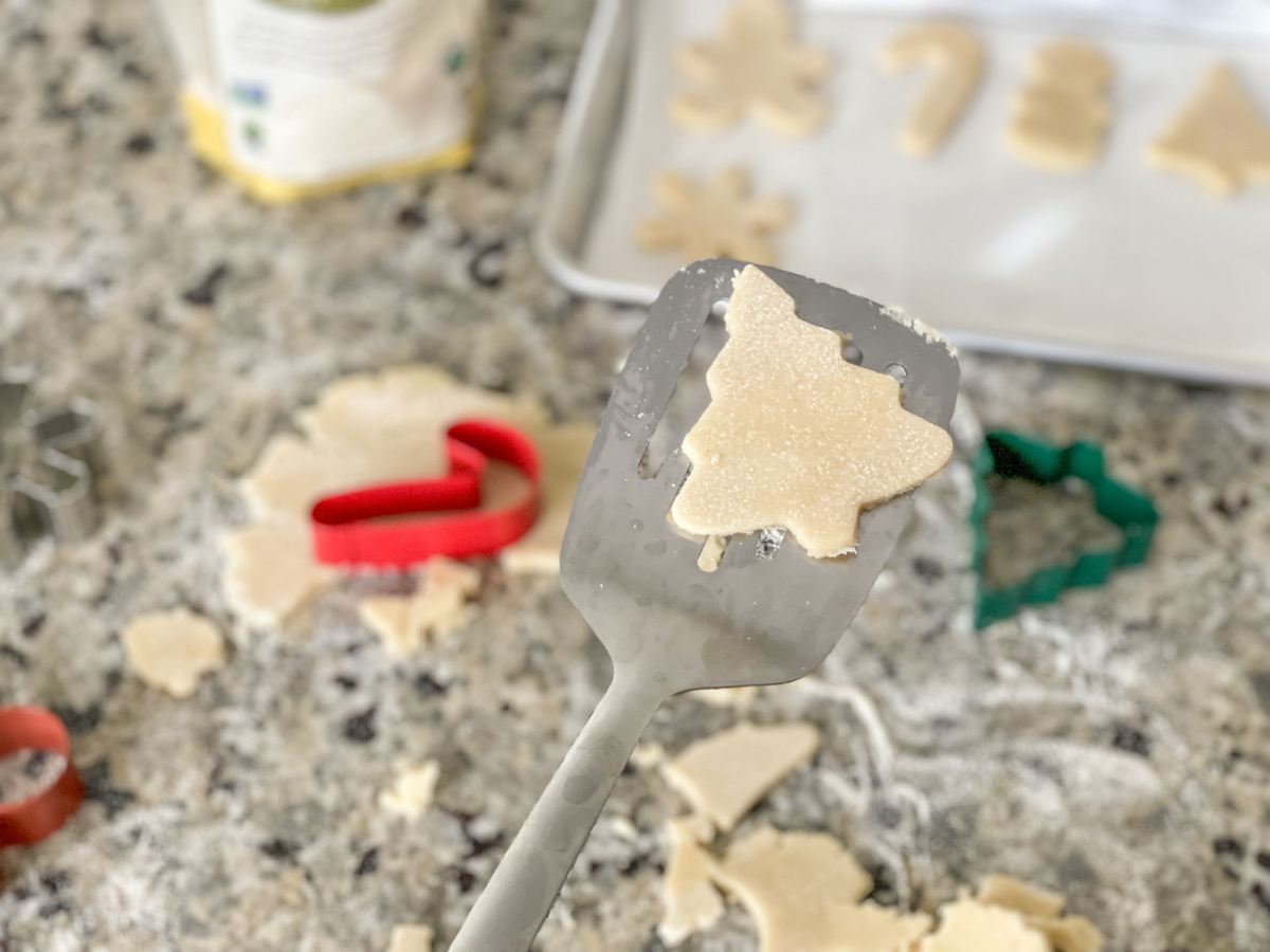 cut out of a tree on a spatula of soft keto sugar cookies