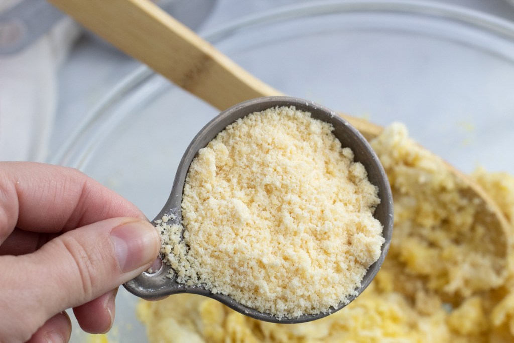 adding almond flour to dough for keto dinner rolls