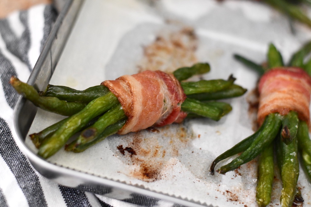 bacon-wrapped green bean bundles on pan 