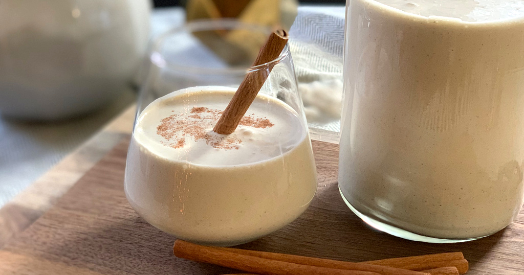 eggnog in glass with cinnamon stick 