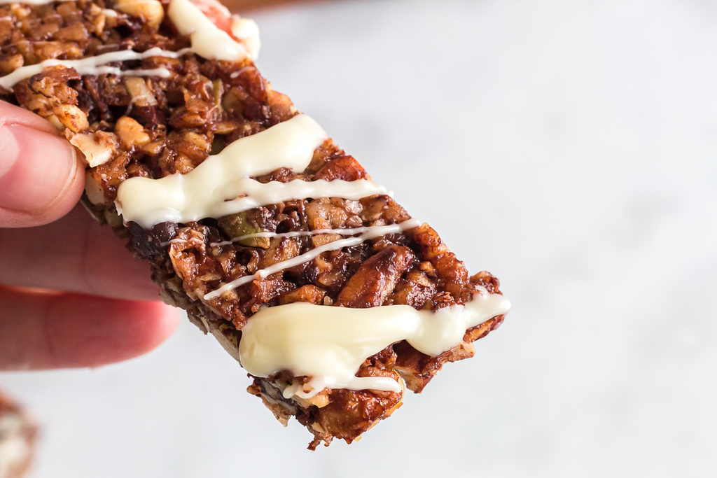 holding keto granola bar with white chocolate 