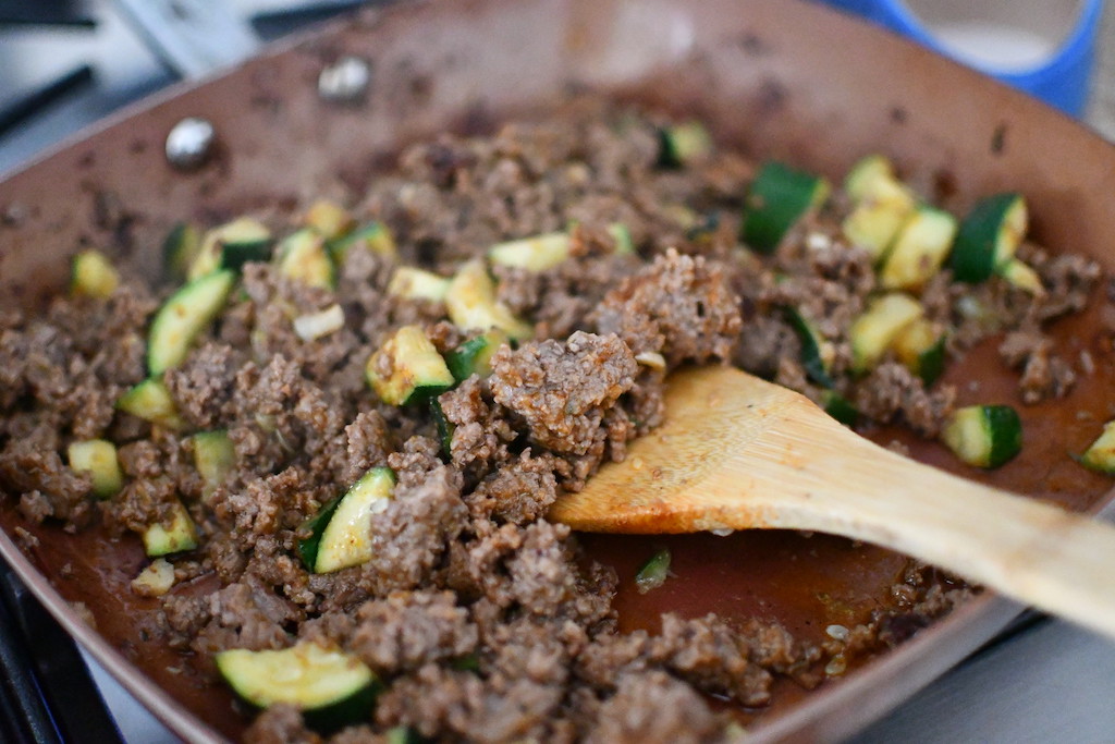 ground beef taco meat in pan with zucchini 