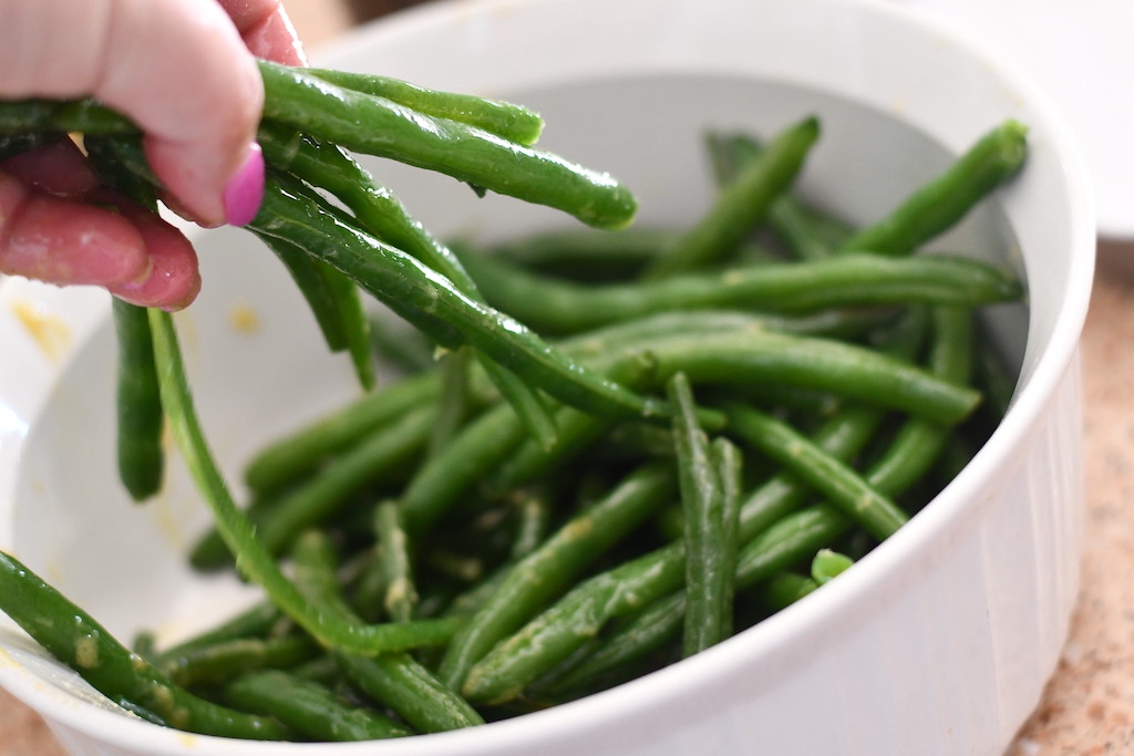 tossing green beans with sauce 