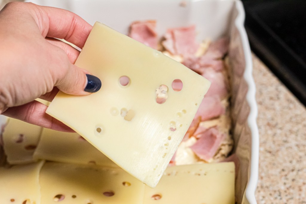 Swiss cheese covering ham in a casserole dish