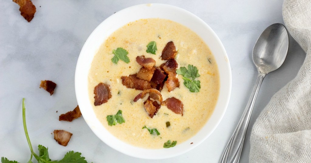 jalapeno popper soup in a bowl topped with bacon and cilantro