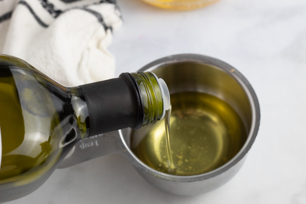 pouring avocado oil into measuring cup