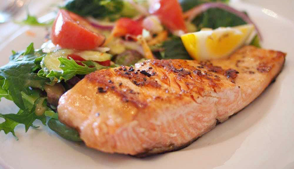 salmon on a plate with salad