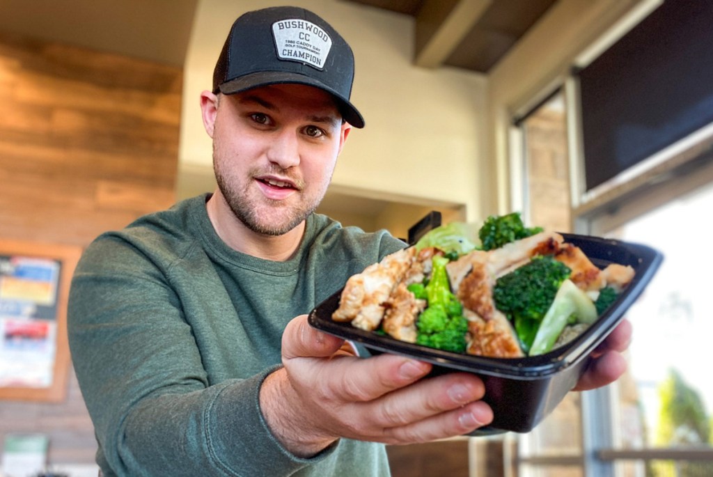 hombre sosteniendo un tazón de pollo de Panda Express