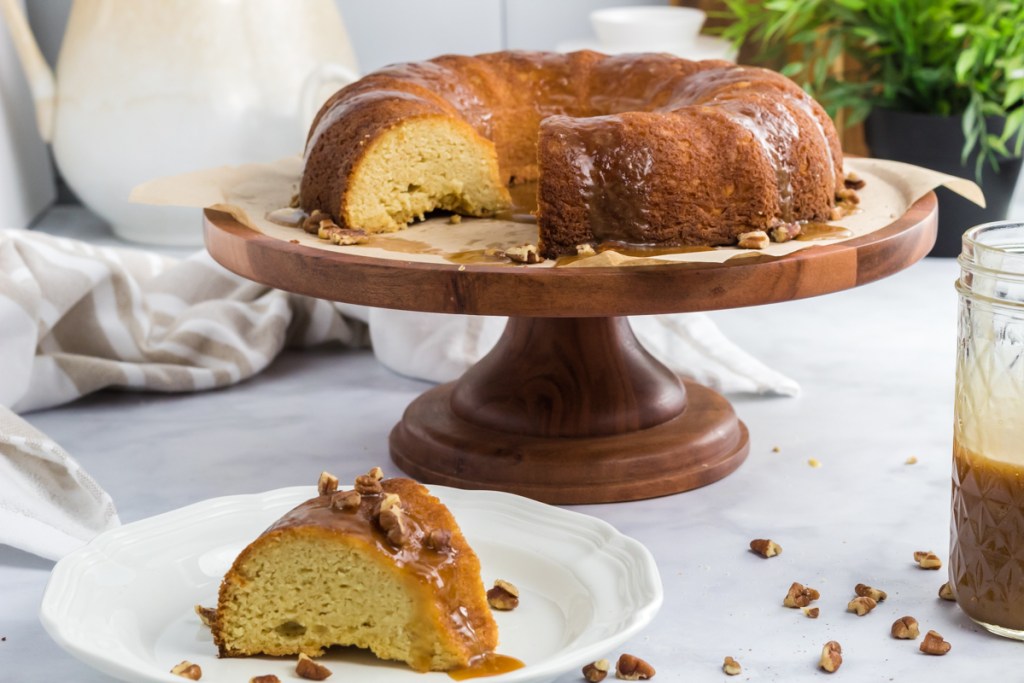 caramel bundt cake on cake stand and slice on plate